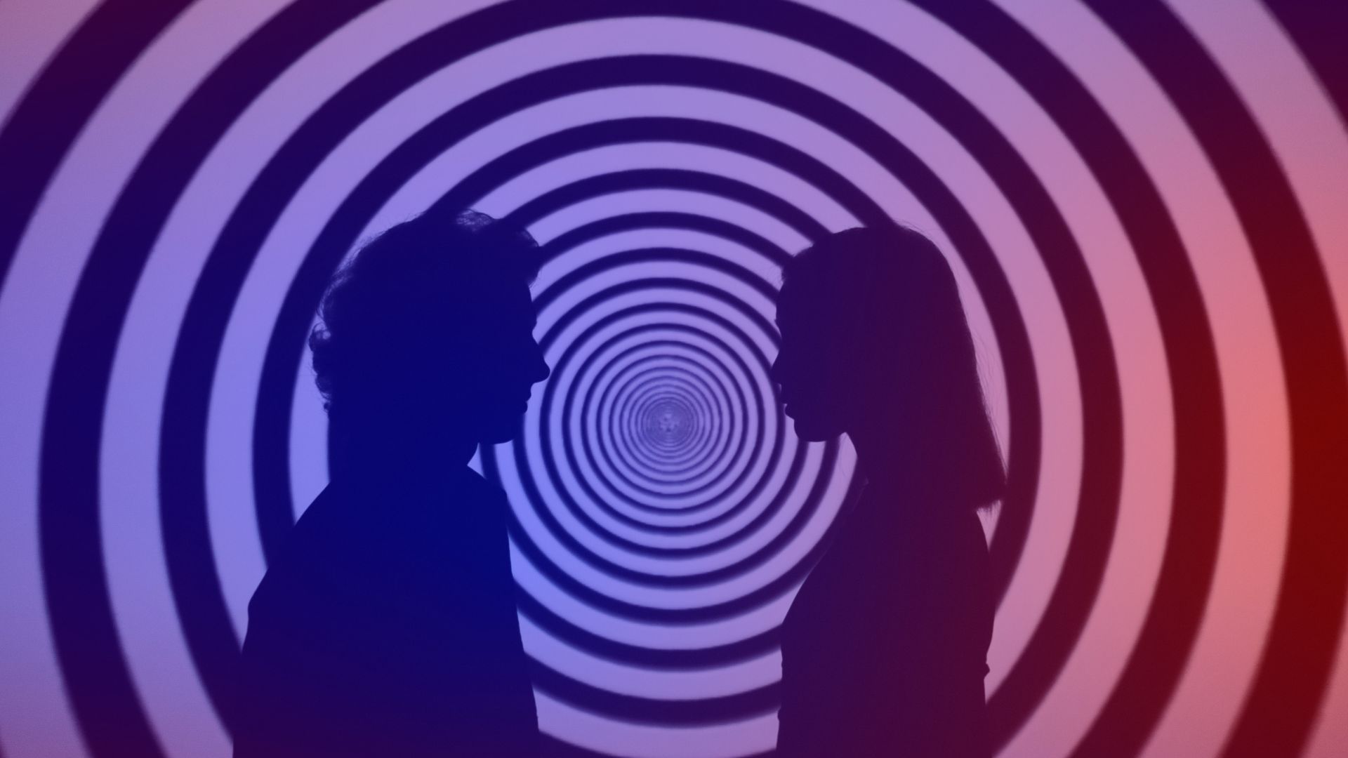 Dark patterns: marketing based on manipulation Graphic of two people in front of a hypnotizing swirl.