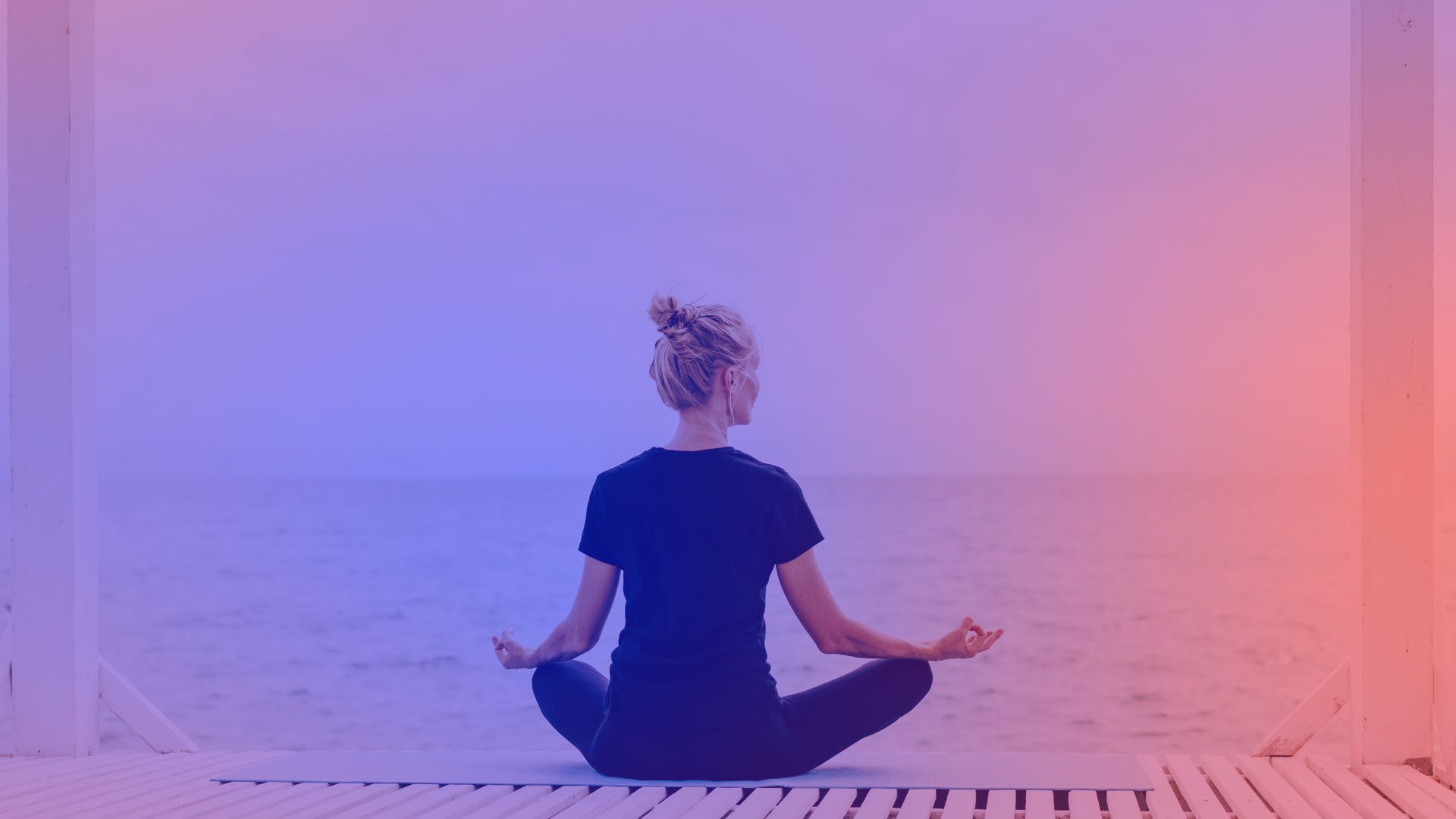 Mental health marketing: A woman sits on a beach, meditating.