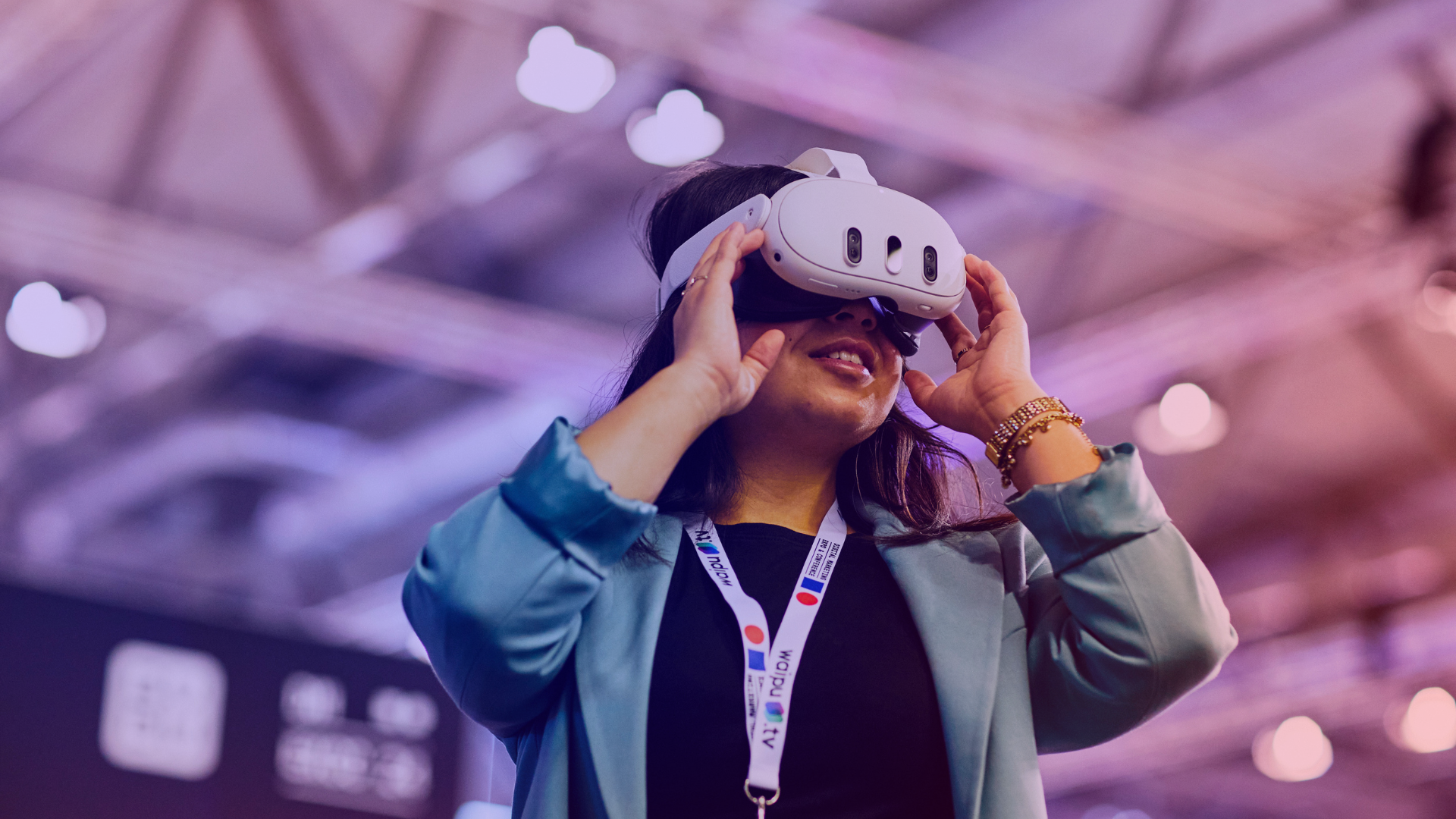 The tech area at DMEXCO 2025: A female visitor tries out a VR headset at the trade fair A woman with a VR headset experiences immersive technology in the tech area at DMEXCO 2025