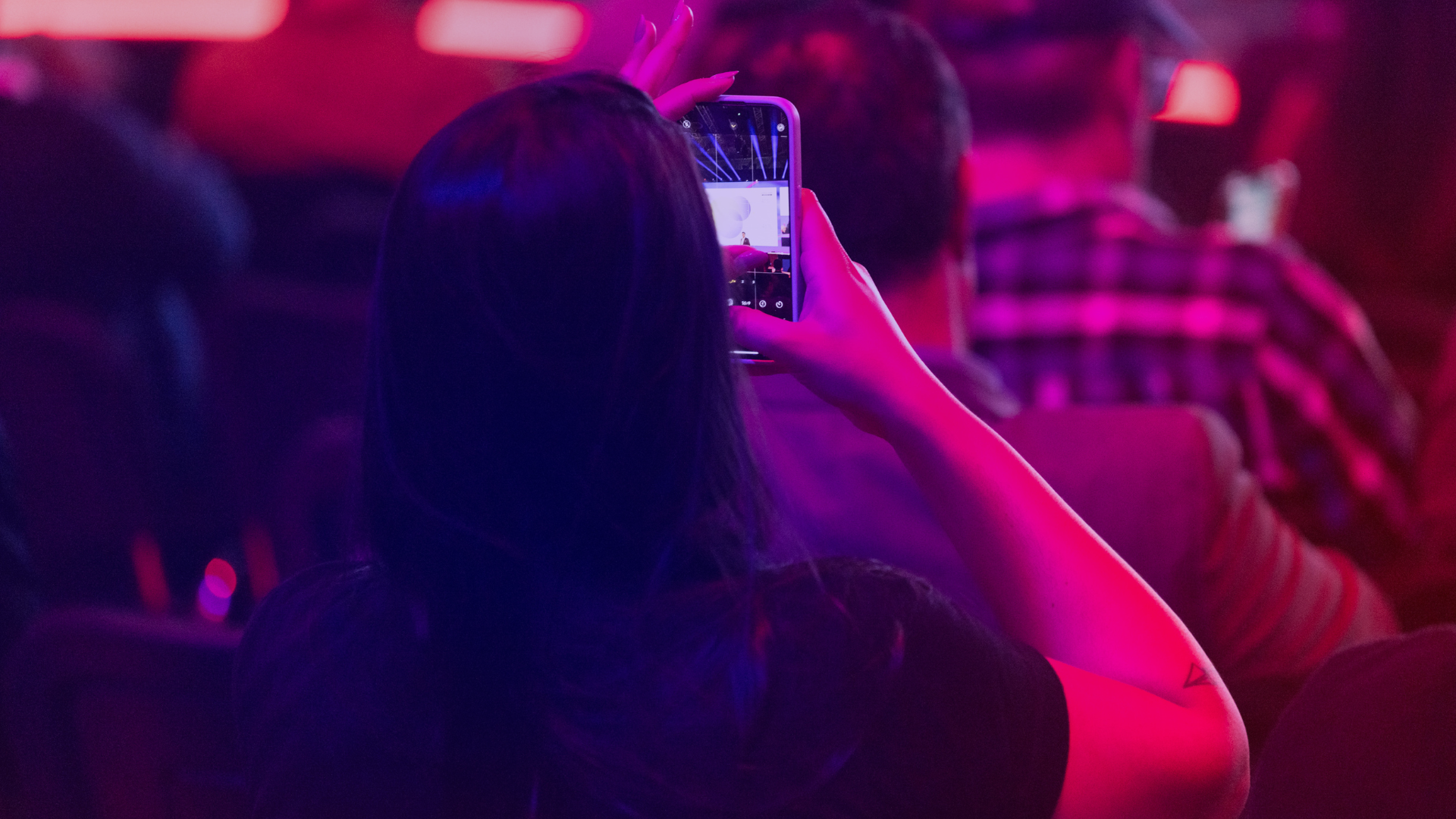 DMEXCO 2025 World of Media: Impression aus dem Publikum Besucherin fotografiert die Bühne mit dem Smartphone in der World of Media auf der DMEXCO 2025