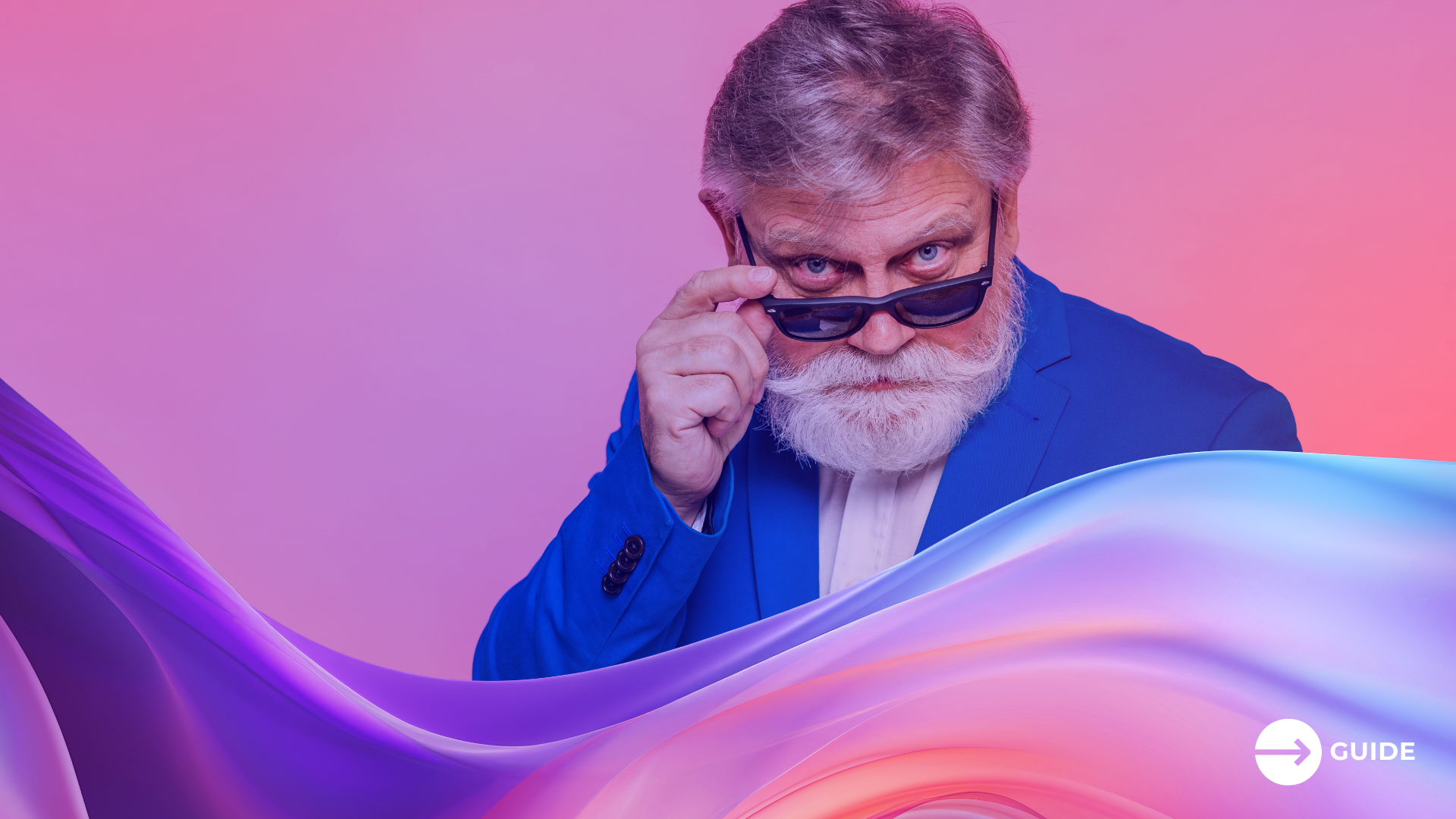 Zielgruppe 50+: Ein älterer Herr im blauen Anzug und mit grauem Bart zieht seine Sonnenbrille herunter.